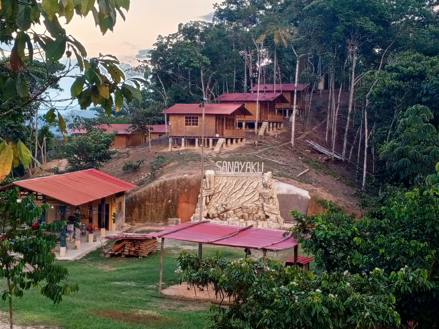 Vista del centro con el letrero de Sanayaku y las construcciones entre la selva